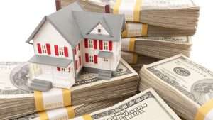 Model home sitting on stacks of cash