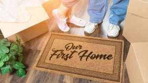 Moving boxes and a welcome mat in young couple's first home